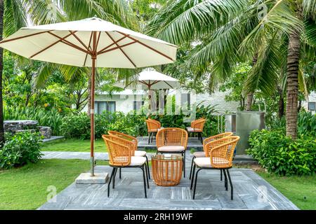 tables et chaises en bambou et rotin dans un jardin tropical calme et verdoyant Banque D'Images