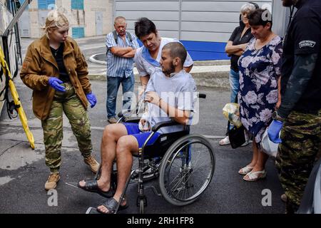 Des volontaires de l’organisation paramédicale hospitalière déplacent un soldat ukrainien blessé vers un bus médical spécial pendant l’évacuation. Les hospitaliers sont un bataillon magique de volontaires ukrainiens qui fournit les premiers soins et évacue les soldats ukrainiens blessés de la zone de guerre depuis 2014. Le bus médicalement équipé des hospitaliers - nommé «autrichien», le surnom d'un ambulancier paramédical hospitalier qui a été tué dans un accident d'un autre bus d'évacuation médicale - peut transporter six patients gravement blessés sur des civières, et plusieurs autres blessés à pied. Banque D'Images