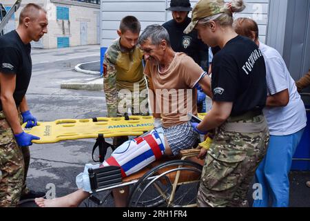 Des volontaires de l’organisation paramédicale hospitalière déplacent un soldat ukrainien blessé vers un bus médical spécial pendant l’évacuation. Les hospitaliers sont un bataillon magique de volontaires ukrainiens qui fournit les premiers soins et évacue les soldats ukrainiens blessés de la zone de guerre depuis 2014. Le bus médicalement équipé des hospitaliers - nommé «autrichien», le surnom d'un ambulancier paramédical hospitalier qui a été tué dans un accident d'un autre bus d'évacuation médicale - peut transporter six patients gravement blessés sur des civières, et plusieurs autres blessés à pied. Banque D'Images