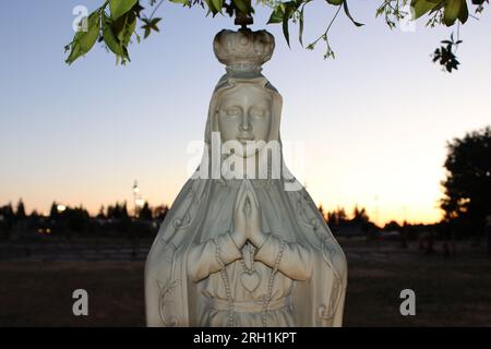 'Sérénité divine - Une statue de marbre captivante d'une femme en prière, évoquant un profond sentiment de paix et de contemplation spirituelle.' Banque D'Images