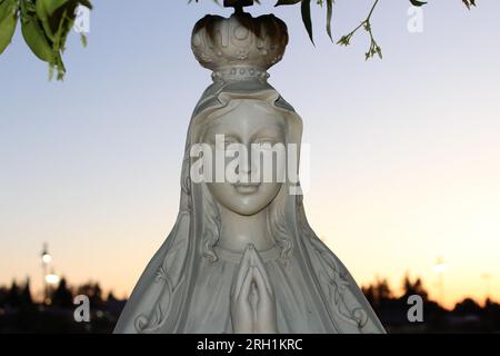 'Sérénité divine - Une statue de marbre captivante d'une femme en prière, évoquant un profond sentiment de paix et de contemplation spirituelle.' Banque D'Images