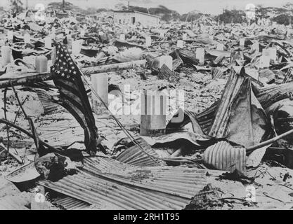 Invasion des Philippines, décembre 1941 – mai 1942. A Manille, un drapeau américain en lambeaux se trouve au milieu d’une vaste mer de destruction au lendemain de la chute de la capitale aux mains des forces impériales japonaises, janvier 1942. Banque D'Images