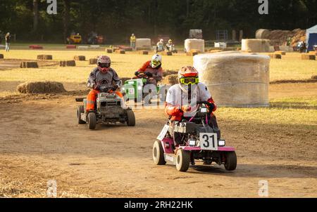 Billingshurst, West Sussex, Royaume-Uni. 12 août 2023. Les pilotes de tondeuse à gazon de course autour d'un virage au lever du soleil dans la BLMRA 500, une course de tondeuse à gazon de nuit de 500 miles style le Mans dans un champ dans le West Sussex, au Royaume-Uni. La British Lawn Mower Racing Association organise son 50e anniversaire de course de 12 heures dans la nuit samedi/dimanche avec 52 équipes, chacune avec jusqu'à trois pilotes. Crédit : Andy Soloman/Alamy Live News Banque D'Images