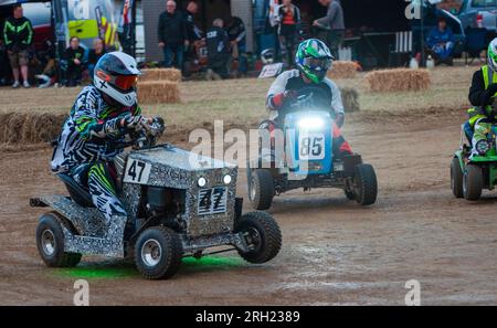 Billingshurst, West Sussex, Royaume-Uni. 12 août 2023. Les pilotes de tondeuse à gazon de course autour d'un virage à l'aube dans la BLMRA 500, une course de tondeuse à gazon de nuit de 500 miles style le Mans dans un champ dans le West Sussex, au Royaume-Uni. La British Lawn Mower Racing Association organise son 50e anniversaire de course de 12 heures dans la nuit samedi/dimanche avec 52 équipes, chacune avec jusqu'à trois pilotes. Crédit : Andy Soloman/Alamy Live News Banque D'Images