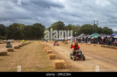 Billingshurst, West Sussex, Royaume-Uni. 12 août 2023. Les pilotes de tondeuse à gazon de course font le tour du circuit tôt le matin dans la BLMRA 500, une course de tondeuse à gazon de nuit de 500 miles dans le style du Mans dans un champ du West Sussex, au Royaume-Uni. La British Lawn Mower Racing Association organise son 50e anniversaire de course de 12 heures dans la nuit samedi/dimanche avec 52 équipes, chacune avec jusqu'à trois pilotes. Crédit : Andy Soloman/Alamy Live News Banque D'Images