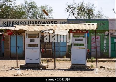 Deux pompes à carburant devant de petits magasins, Nakuru, Kenya Banque D'Images