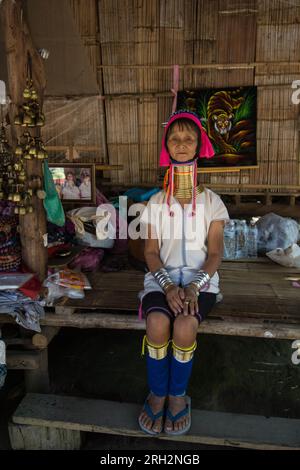 Thaïlande dame assise dans bambou maison art art cloches cloche tigre cou collier long cou visage personne vieille femme look boutique vendant des marchandises tribu Karen Banque D'Images