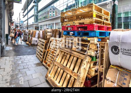 Paquets d'emballages en carton et palettes en bois en attente de collecte dans le centre-ville - Bruxelles, Belgique. Banque D'Images