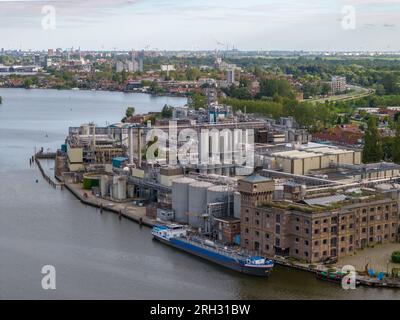 Photo aérienne par drone d'une barge de cargaison amarrée dans une zone industrielle à Wormerveer, aux pays-Bas Banque D'Images