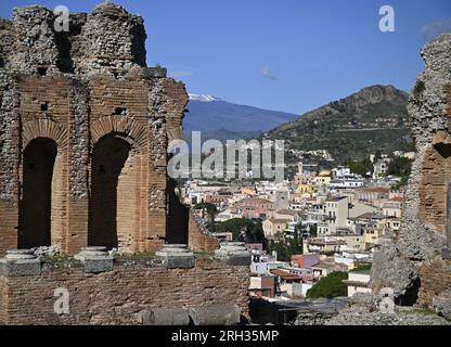 Paysage avec vue panoramique sur Taormina vu du Greco Romano Teatro Antico un monument historique surplombant l'Etna en Sicile, Italie. Banque D'Images