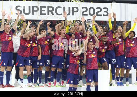 MUNICH, Allemagne - 12. AOÛT 2023 : 4 Willi Orban (C) avec trophée, les joueurs du RB Leipzig célèbrent avec le trophée des vainqueurs après avoir remporté le match Supercup 2023 entre le FC Bayern München et le RB Leipzig à l'Allianz Arena le 12 août à Munich, Allemagne. DFL, Fussball, 0:3 (photo et copyright @ ATP images/Arthur THILL FC RB-LEIPZIG joueurs et remplaçants pour ce match : 21 Janis Blaswich (Keeper), 2 Mohamed Simakan, 4 Willi Orban (C), 7 Dani Olmo, 11 Timo Werner, 17 lois Openda, 20 Xavi Simons, 22 David Raum, 24 Xaver Schlager, 39 Benjamin Henrichs, 44 Kevin Kampl, 9 Yussuf Poulsen, 10 Emil Banque D'Images