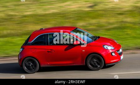 Milton Keynes, Royaume-Uni - 11 août 2023 : voiture rouge 2017 Vauxhall Adam conduisant sur une route de campagne anglaise. Banque D'Images