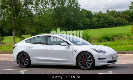 Milton Keynes, Royaume-Uni - 13 août 2023 : 2020 voiture électrique blanche Tesla Model 3 Performance conduisant sur une route de campagne anglaise. Banque D'Images