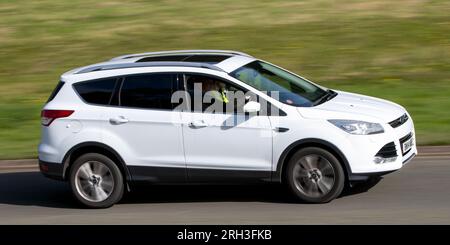 Milton Keynes, Royaume-Uni - 10 août 2023 : 2014 Ford Kuga voiture blanche conduisant sur une route de campagne anglaise. Banque D'Images