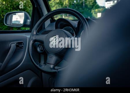 Ingénierie allemande : un intérieur de marque de voiture allemande avec fokus sur le volant en cuir massif au milieu est l'emblème VW Banque D'Images