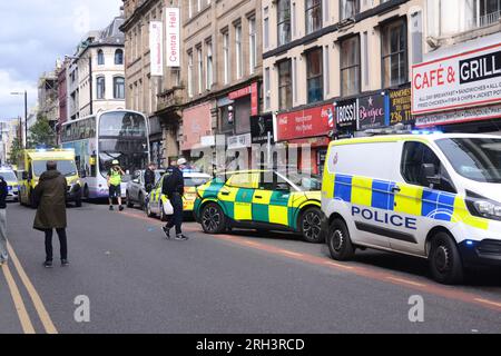 Manchester, Royaume-Uni. 13 août 2023. La police du Grand Manchester a fermé Oldham Street, dans le centre de Manchester, au Royaume-Uni, dimanche. À 16,24 h 30, un homme a été étiré hors du magasin Mini Market pour se rendre à une ambulance et emmené à l'hôpital. Un porte-parole de la police a déclaré : « cela est traité comme un incident isolé et la victime - un homme de 27 ans - a été emmenée à l'hôpital pour le traitement de blessures graves, bien que celles-ci ne soient heureusement pas considérées comme mettant la vie en danger. Une enquête est en cours et une scène a été mise en place pour faciliter les enquêtes. » Crédit : Terry Waller/Alamy Live News Banque D'Images