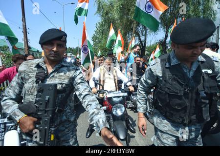 Srinagar, Inde. 13 août 2023. Les membres du BJP et les locas tiennent des drapeaux nationaux lorsqu'ils participent au rassemblement à vélo et à pied 'Meri Maati Mera Desh' (mon sol, mon pays) avant les célébrations de la fête de l'indépendance le 12 août 2023 à Srinagar, en Inde. (Photo de Mubashir Hassan/Pacific Press) crédit : Pacific Press Media production Corp./Alamy Live News Banque D'Images