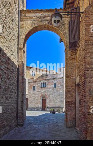 Ville de Bevagna, Ombrie, Italie. Ruelle avec arche qui mène à la place Silvestri, en arrière-plan l'église St Sylvester (1195). Banque D'Images