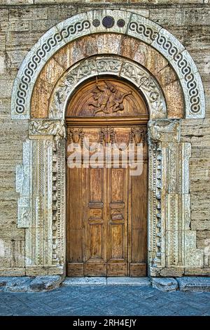 Ville de Bevagna, Ombrie, Italie. Le beau portail médian dans la façade de l'église Saint-Michel du 12e siècle. Banque D'Images