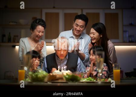 joyeuse famille asiatique de trois générations célébrant l'anniversaire de grand-père à la maison Banque D'Images