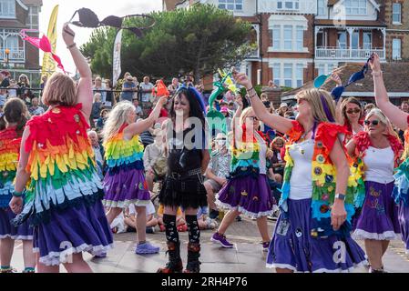 Broadstairs, Royaume-Uni. 12 août 2023. Les danseuses de The Loose Women Morris tournent les soutiens-gorge sur leurs têtes pendant qu'elles marchent autour d'une personne gothique. Broadstairs organise cette année la 57e Folk week. C'est l'un des plus grands festivals folkloriques du Royaume-Uni. Des centaines de danseuses Morris ont pris les rues et des groupes ayant des concerts dans les pubs. Crédit : SOPA Images Limited/Alamy Live News Banque D'Images