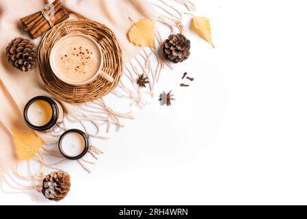 Composition d'automne avec café, feuilles sèches, bougies et pommes de pin isolé sur fond blanc. Tasse de café cappuccino avec des épices de citrouille et tiède Banque D'Images