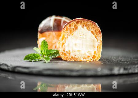 Délicate boule de pâte à choux sans gluten remplie de crème de pâtisserie bavaroise. Banque D'Images