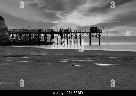 Cabanes ou cabanes de pêche familiales traditionnelles en bois, construites sur pilotis et accessibles par des passerelles depuis le rivage, Talmont-sur-Gironde, Nouvelle-Aquitaine, France. Version noir et blanc de la photographie originale. Banque D'Images