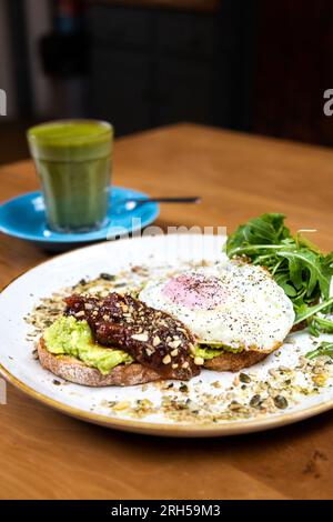 Avocat écrasé sur pain au levain avec oeuf, chutney et dukkah au stables Cafe par Orleans House Gallery, Twickenham, Londres, Angleterre Banque D'Images