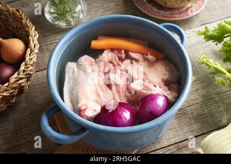 Dos de poulet et légumes frais dans une casserole d'eau - Ingrédients pour préparer du bouillon ou de la soupe Banque D'Images