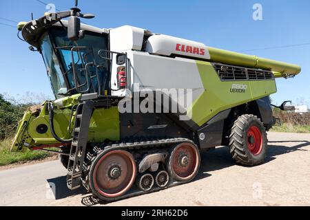 Une moissonneuse-batteuse Claas Lexion 880 en route pour amener le blé, dans une fenêtre étroite de beau temps, donnant une teneur en humidité favorable Banque D'Images