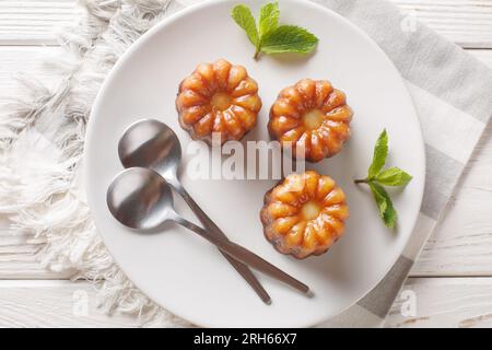 Canele est une petite pâtisserie française aromatisée au rhum et à la vanille avec un centre de crème douce et tendre et une croûte caramélisée foncée et épaisse en gros plan Banque D'Images