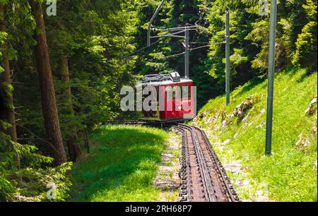 Superbe vue rapprochée d'un train à crémaillère rouge approchant. C'est le chemin de fer Pilatus, un chemin de fer de montagne en Suisse et le rack le plus raide... Banque D'Images