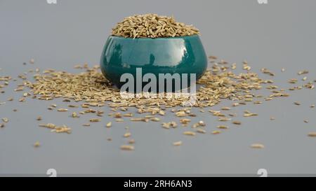 Graines de cumin appelées Jeera dans un bol vert Lite sur fond gris sélectif Focus Banque D'Images