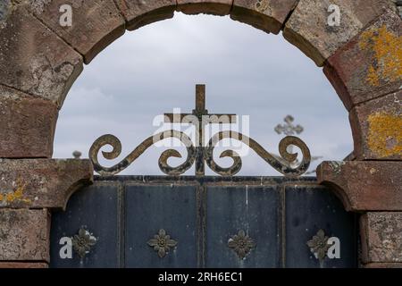 Mystérieuse porte métallique de cimetière avec fond de croix et de croix Banque D'Images