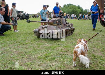 Char de l'Armée Panther allemande à très grande échelle radiocommandée, de la Seconde Guerre mondiale lors d'un événement militaire extérieur, avec un chien et des enfants pour l'échelle Banque D'Images