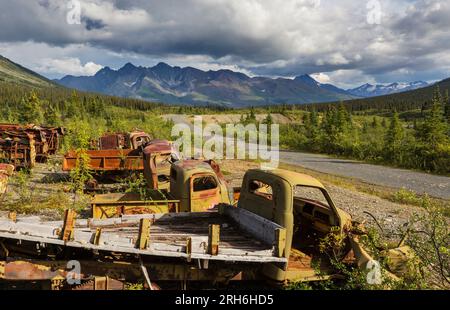 Une gamme de camions rouillés abandonnés après la guerre qui rouillent dans le désert pendant l'été dans le nord du Canada Banque D'Images