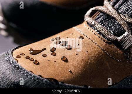 bottes en cuir imperméables. gros plan des gouttes de pluie sur les chaussures résistantes à l'eau. vêtements résistants aux intempéries Banque D'Images