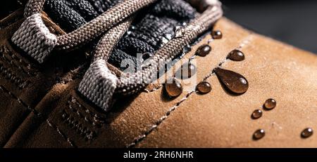 chaussures en cuir imperméables. gros plan des gouttes de pluie sur les chaussures résistantes à l'eau. vêtements résistants aux intempéries Banque D'Images