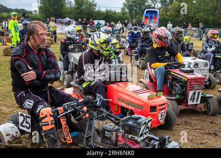 Les pilotes s'assoient sur leurs tondeuses de course en attendant de se voir attribuer des positions de départ dans le cadre du British Lawn Mower Racing Associ, une course annuelle de tondeuses à gazon de style le Mans Banque D'Images