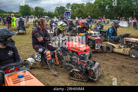 Les pilotes s'assoient sur leurs tondeuses de course en attendant de se voir attribuer des positions de départ dans le cadre du British Lawn Mower Racing Associ, une course annuelle de tondeuses à gazon de style le Mans Banque D'Images