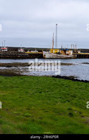 Grindavik, Islande - 29 juin 2023 : vieux bateau de pêche rouillé dans le petit port d'un village de la péninsule de Reykjanes Banque D'Images