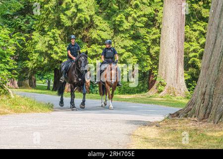 Deux policiers de Vancouver patrouillent Stanley Park à cheval. Banque D'Images