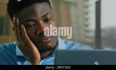 Homme d'affaires multiracial fatigué surtravaillé ordinateur portable travail à distance somnolent épuisé paresseux homme afro-américain sans motivation employé gestionnaire Banque D'Images