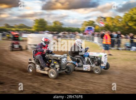 Les pilotes de tondeuses à gazon de course se bousculent pour se positionner dans la BLMRA 500, une course de tondeuses à gazon de nuit de 500 miles dans le style du Mans dans un champ du West Sussex, au Royaume-Uni. TH Banque D'Images