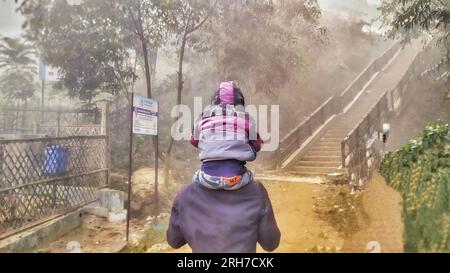 Un père et un enfant marchant tôt le matin au camp de réfugiés de Balukhali. Environ 919 000 000 réfugiés Rohingyas vivent dans les camps de Kutupalong et de Nayapara dans la région de Cox’s Bazar, qui sont devenus l’un des camps les plus vastes et les plus densément peuplés au monde. Bangladesh. Banque D'Images