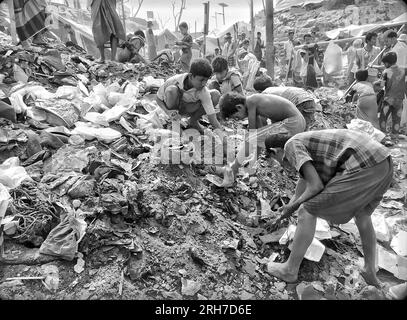 Garçons travaillant dans une zone de collecte des ordures du camp de réfugiés de Balukhali. Environ 919 000 000 réfugiés Rohingyas vivent dans les camps de Kutupalong et de Nayapara dans la région de Cox’s Bazar, qui sont devenus l’un des camps les plus vastes et les plus densément peuplés au monde. Bangladesh. Banque D'Images