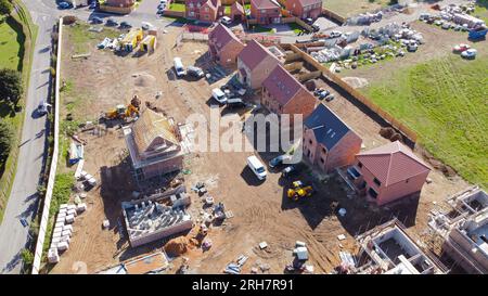 Vue aérienne drone d'un grand domaine de maisons neuves de qualité en construction et montrant les différentes étapes de construction. Banque D'Images