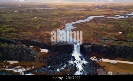 Drone shot de la cascade d'oxarafoss en islande, spectaculaire cascade nordique qui coule vers le bas créant un paysage scandinave. Magnifique ruisseau islandais tombant. Banque D'Images