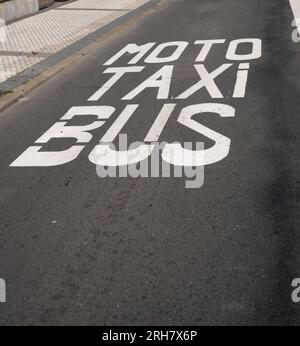 Les mots moto, taxi et bus sont peints dans la rue. Ils marquent une voie spéciale dans la circulation. Banque D'Images